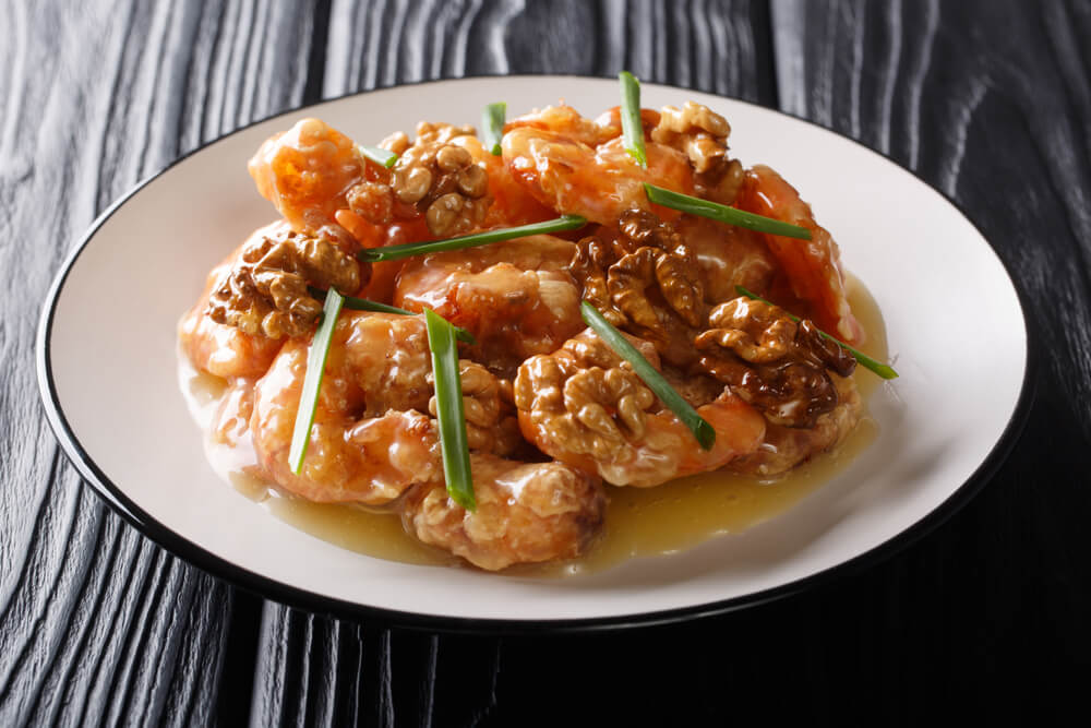 Fried shrimp, sweet creamy sauce and candied walnuts close-up.